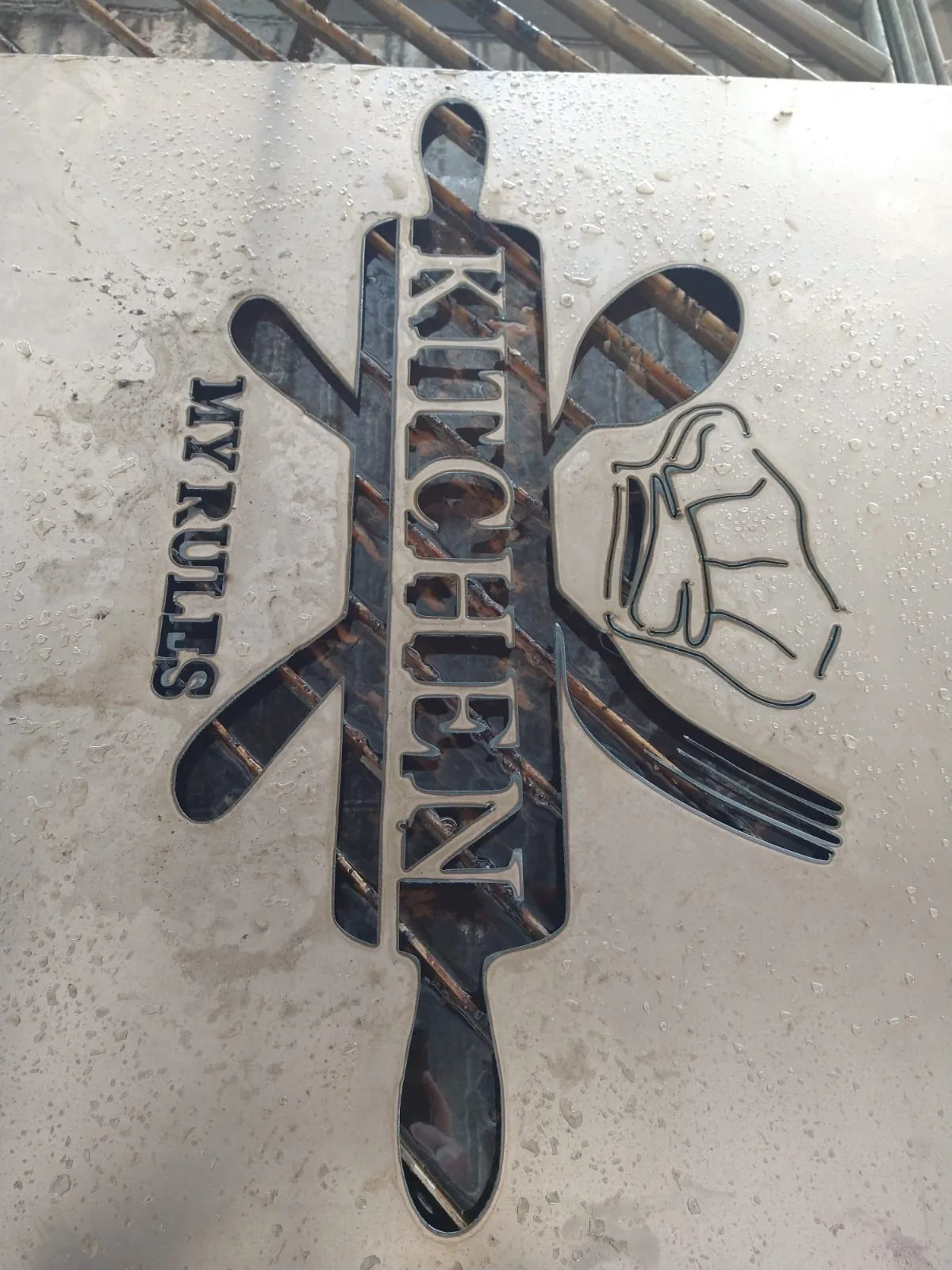 Logotipo de restaurante cortado en una sola placa de acero