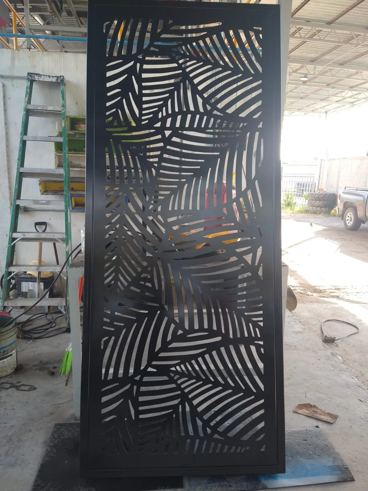 Puerta de acero con celosía de hoja de palma cortada por plasma